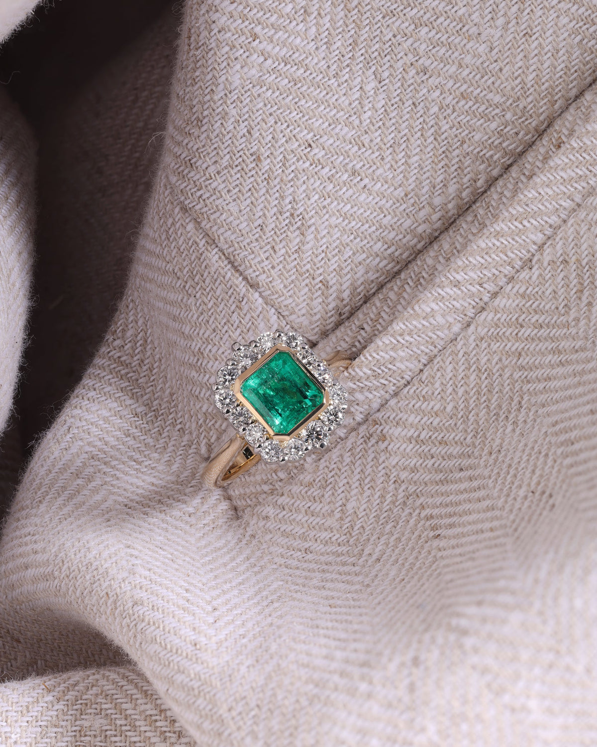 Gold ring with a green gemstone on a textured fabric background