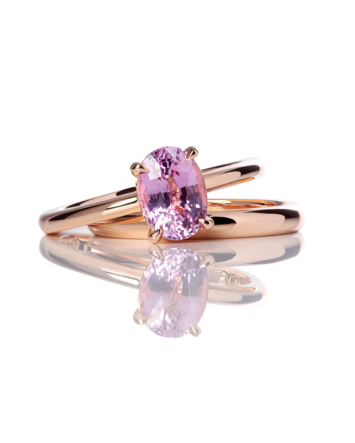 An 18ct rose gold engagement ring with a sculptured four claw setting, featuring a pink to purple hue sapphire gemstone. The band is separate and not included in the ring's valuation.